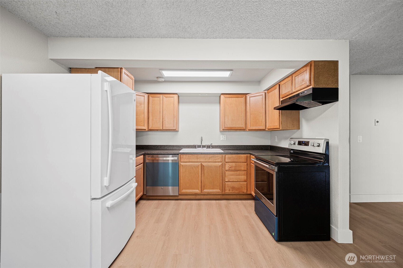210 Southwest Clark Street, Unit A202 Issaquah, WA 98027 - Photo 9 of 28 a kitchen with stainless steel appliances granite countertop a refrigerator and a stove top oven
