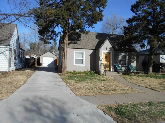 a view of an empty room with wooden floor fireplace and a window