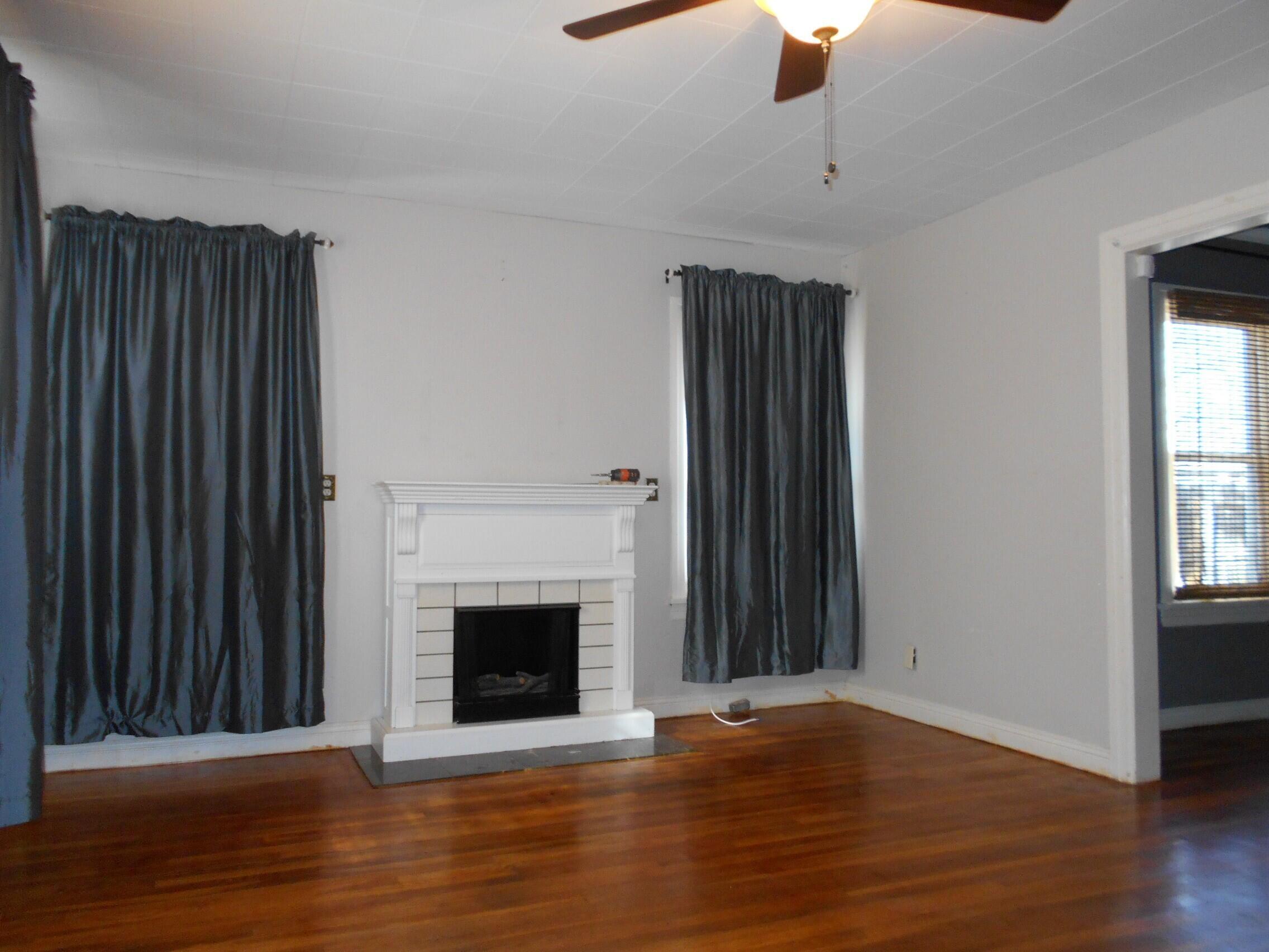2518 25th Street Lubbock, TX 79410 - Photo 21 of 39 a view of a livingroom with wooden floor a fireplace and window