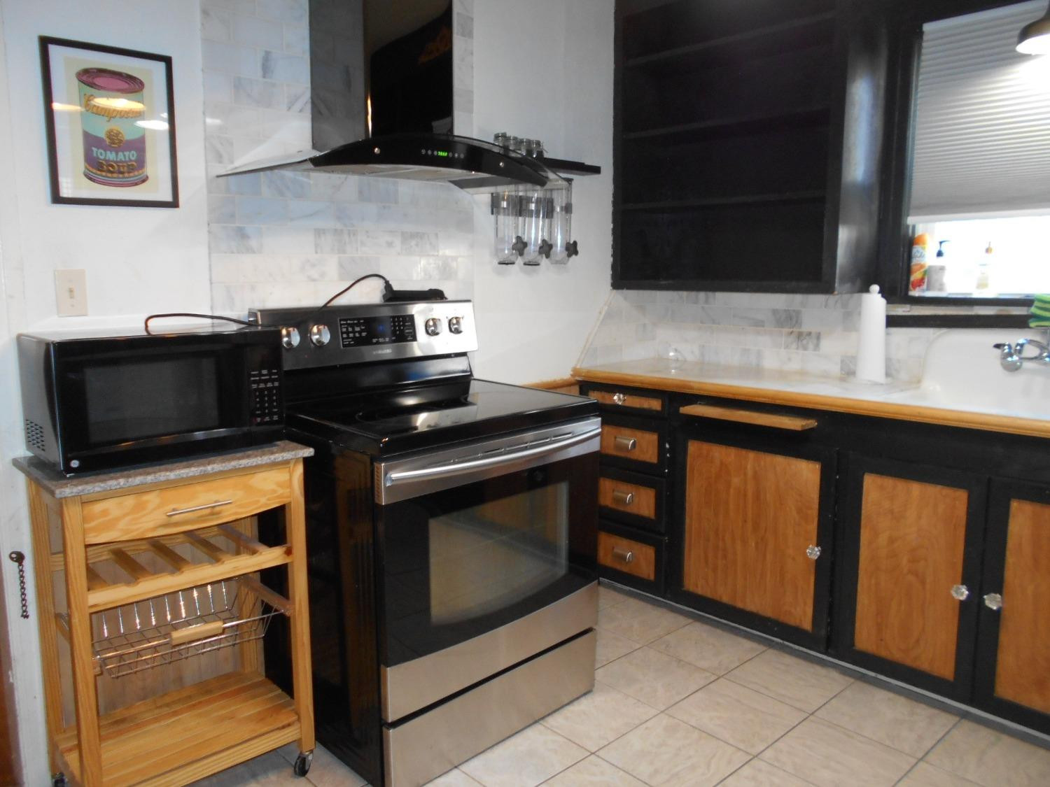 2518 25th Street Lubbock, TX 79410 - Photo 8 of 39 a kitchen with stainless steel appliances a stove a sink and a microwave