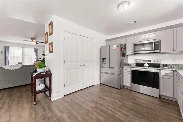 a kitchen with a refrigerator cabinets and wooden floor