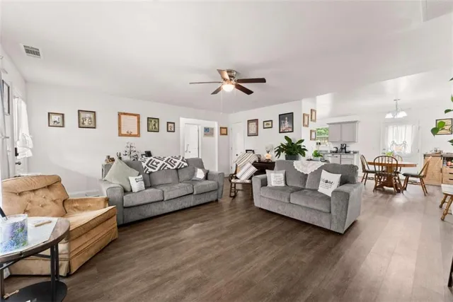 a living room with furniture white walls and wooden floor