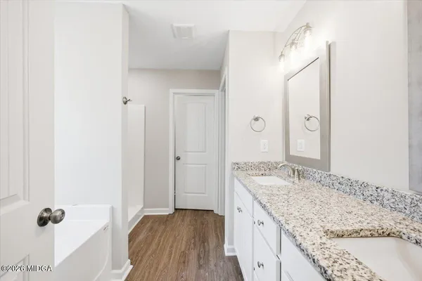 a spacious bathroom with a granite countertop sink and a mirror