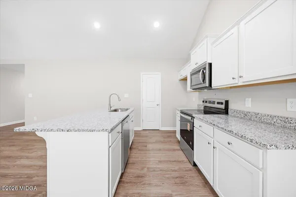 a kitchen with granite countertop a sink and cabinets
