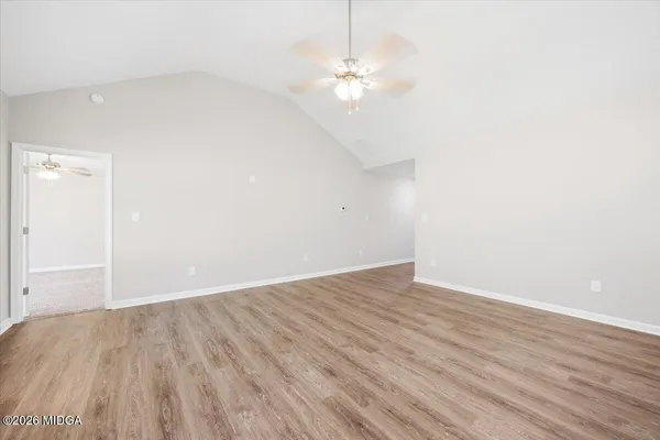 a view of an empty room with wooden floor