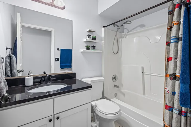 a bathroom with a granite countertop sink toilet and shower