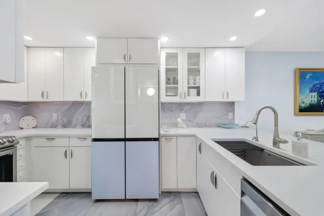 a kitchen with a sink a refrigerator and cabinets