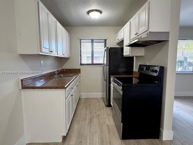 1310 West 29th Street, Unit 31 Hialeah, FL 33012 - Photo 4 of 13 a kitchen with granite countertop a refrigerator a stove top oven a sink and dishwasher with wooden floor