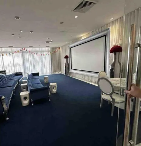 a living room with furniture a projector and screen