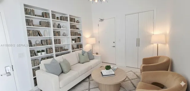 a living room with furniture and a book shelf