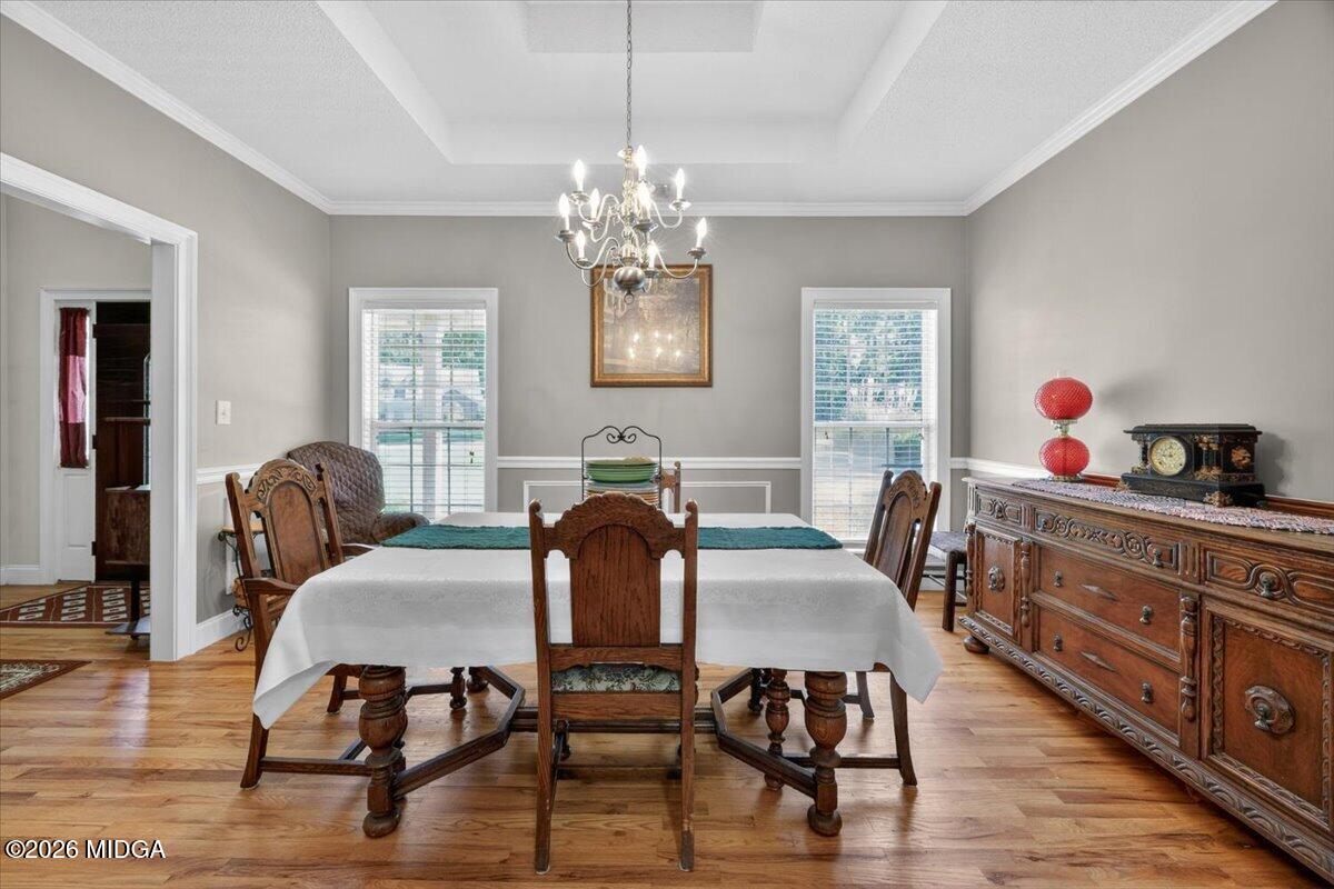 619 Grayridge Road Gray, GA 31032 - Photo 12 of 40 a view of a dining room with furniture a chandelier and wooden floor