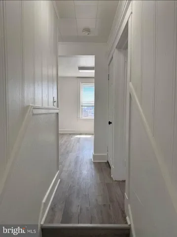 a view of a hallway with wooden floor