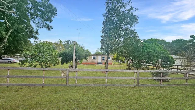a backyard of a house with a yard and outdoor seating