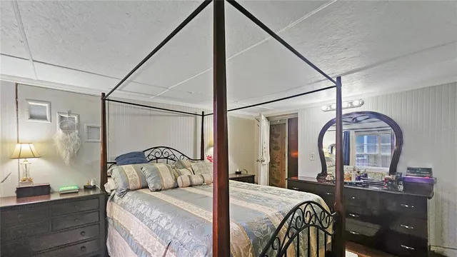 a bedroom with a bed and a painting on the wall