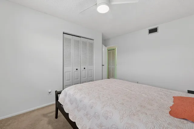 a bedroom with a bed and a lamp on the dresser