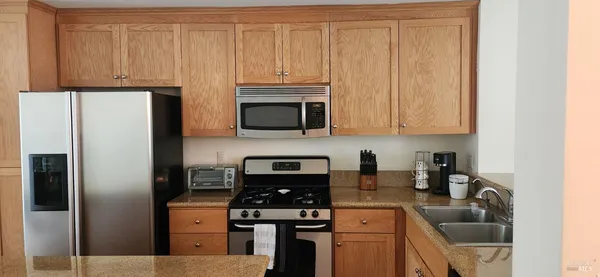 a kitchen with stainless steel appliances granite countertop a refrigerator stove and sink