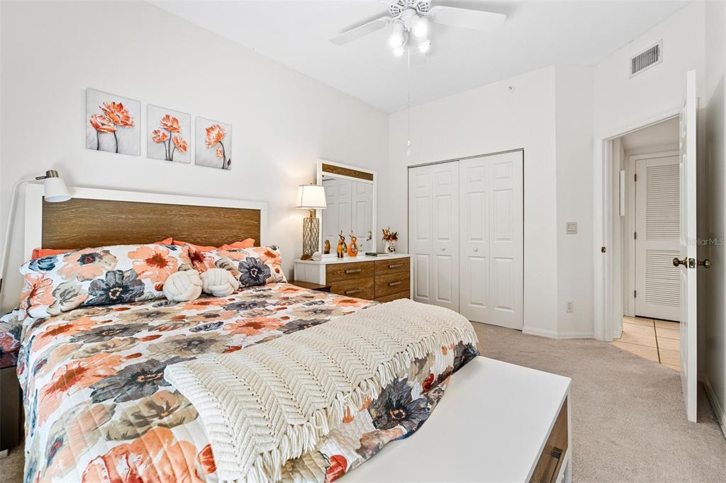 6555 99th Way North, Unit 20F St. Petersburg, FL 33708 - Photo 26 of 36 a bedroom with a large bed and a chandelier