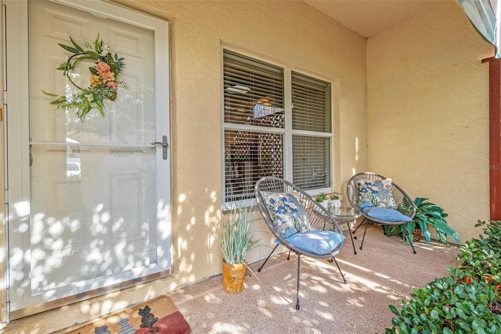 6555 99th Way North, Unit 20F St. Petersburg, FL 33708 - Photo 4 of 36 a view of a porch with chairs and potted plants