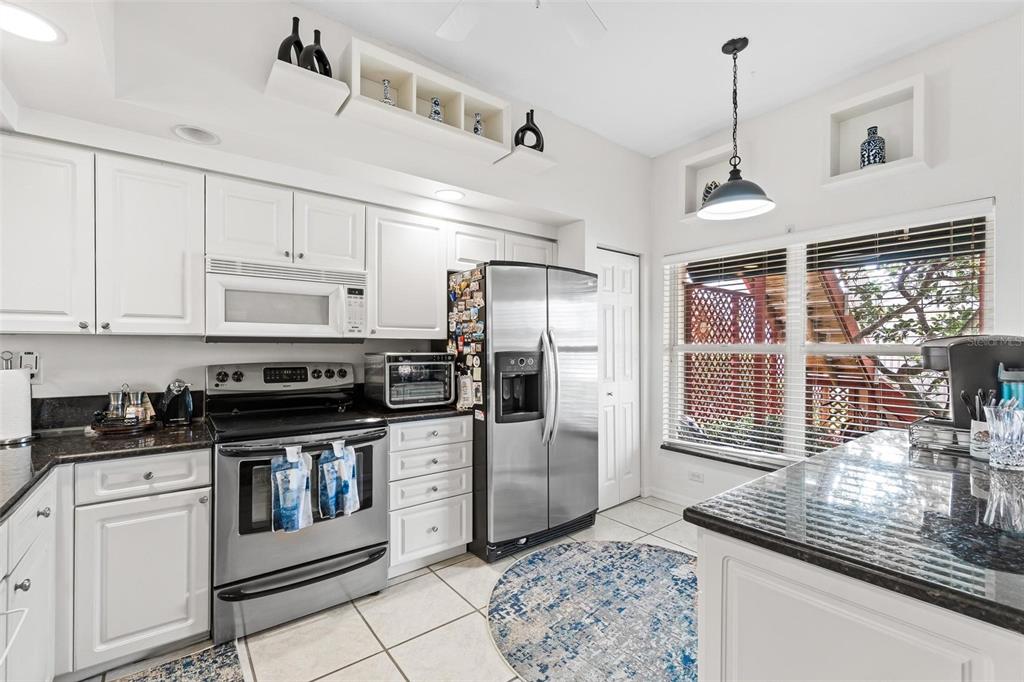 6555 99th Way North, Unit 20F St. Petersburg, FL 33708 - Photo 10 of 36 a kitchen with stainless steel appliances granite countertop a stove a sink and a refrigerator