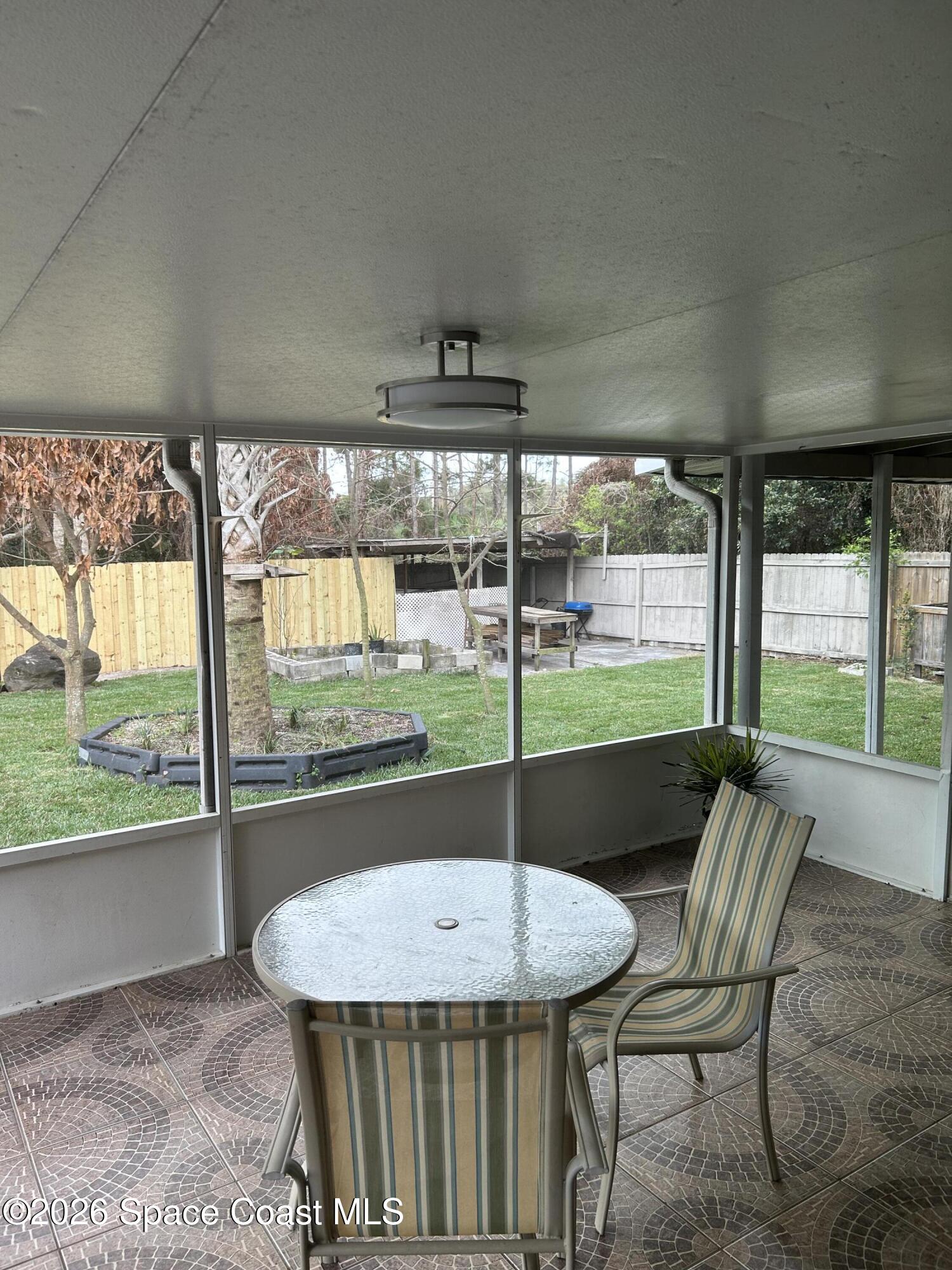3785 Bird Street Cocoa, FL 32927 - Photo 5 of 15 a view of a patio with a table chairs and a backyard