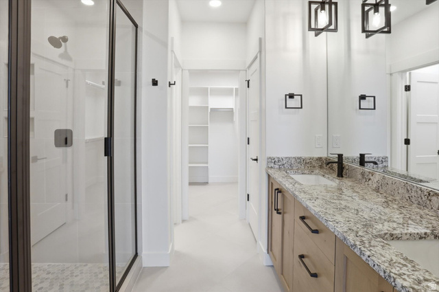 1315 West 3200 South, Unit 17 Perry, UT 84302 - Photo 31 of 58 Spacious bathroom featuring a glass-enclosed shower, dual vanity with stone countertop, wood-finish cabinetry, and contemporary lighting fixtures