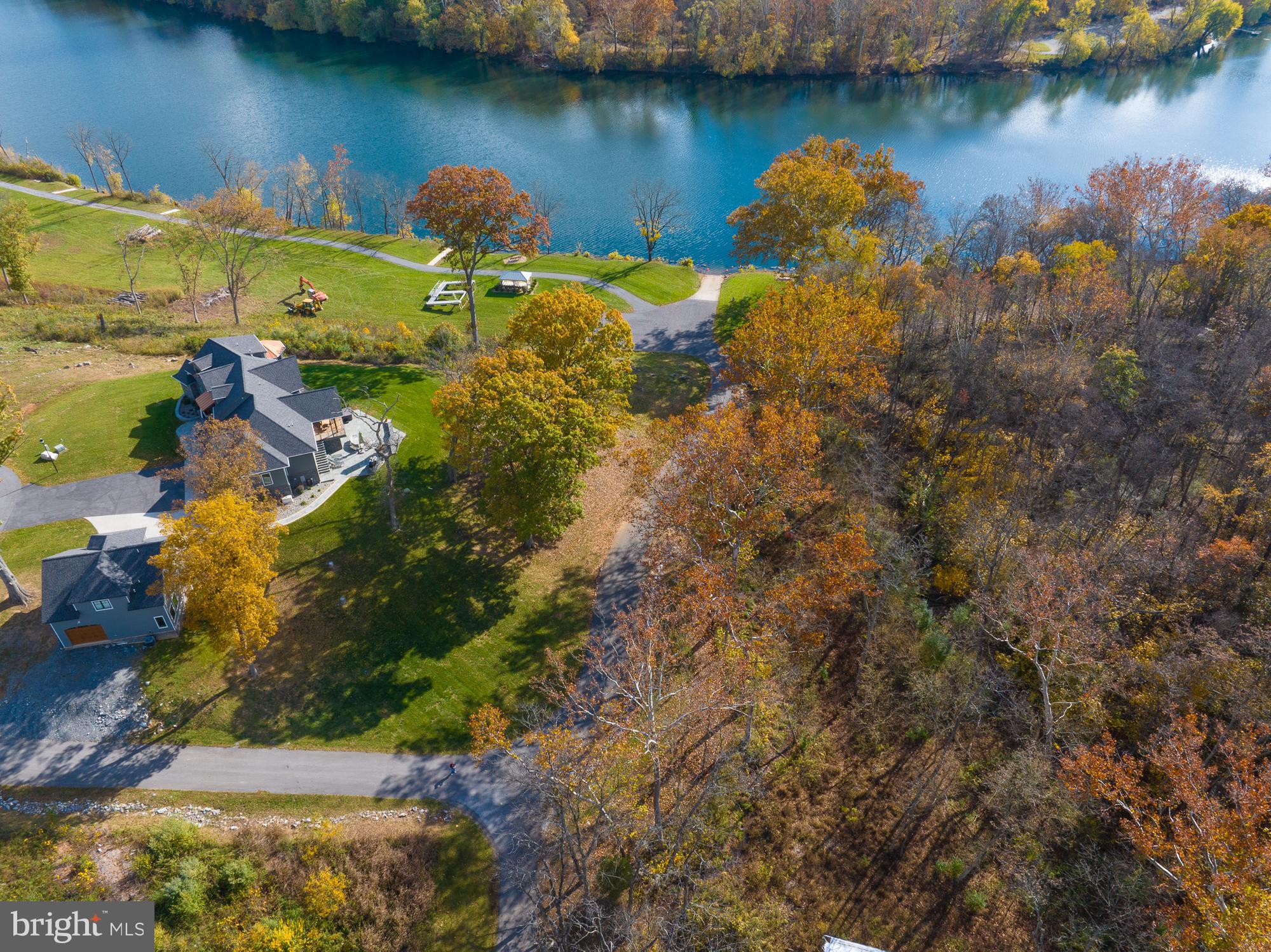 38 Whitings Neck Road, Unit POTOMAC OVERLOOK Martinsburg, WV 25404 - Photo 10 of 40 a view of a lake with lawn chairs and large trees