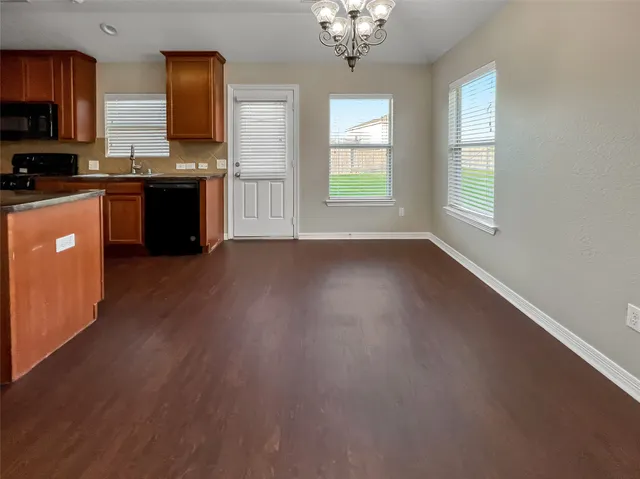 a kitchen with stainless steel appliances granite countertop a stove top oven a sink dishwasher with wooden floor and cabinets