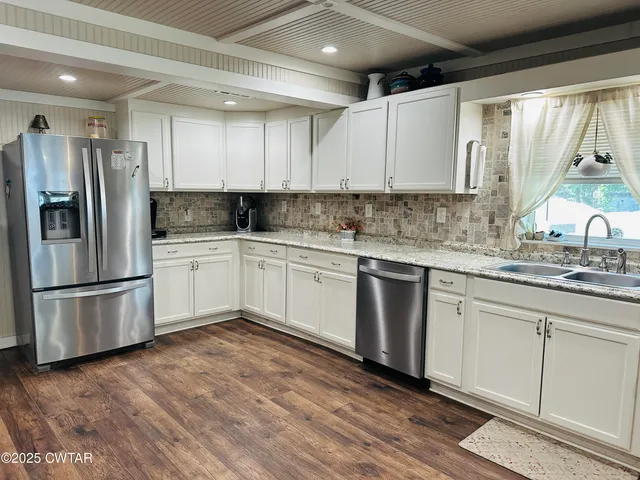a kitchen with granite countertop white cabinets and a window