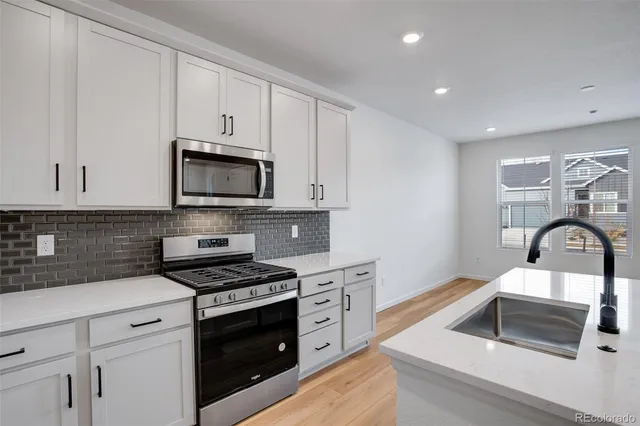 a kitchen with a sink and wooden floor