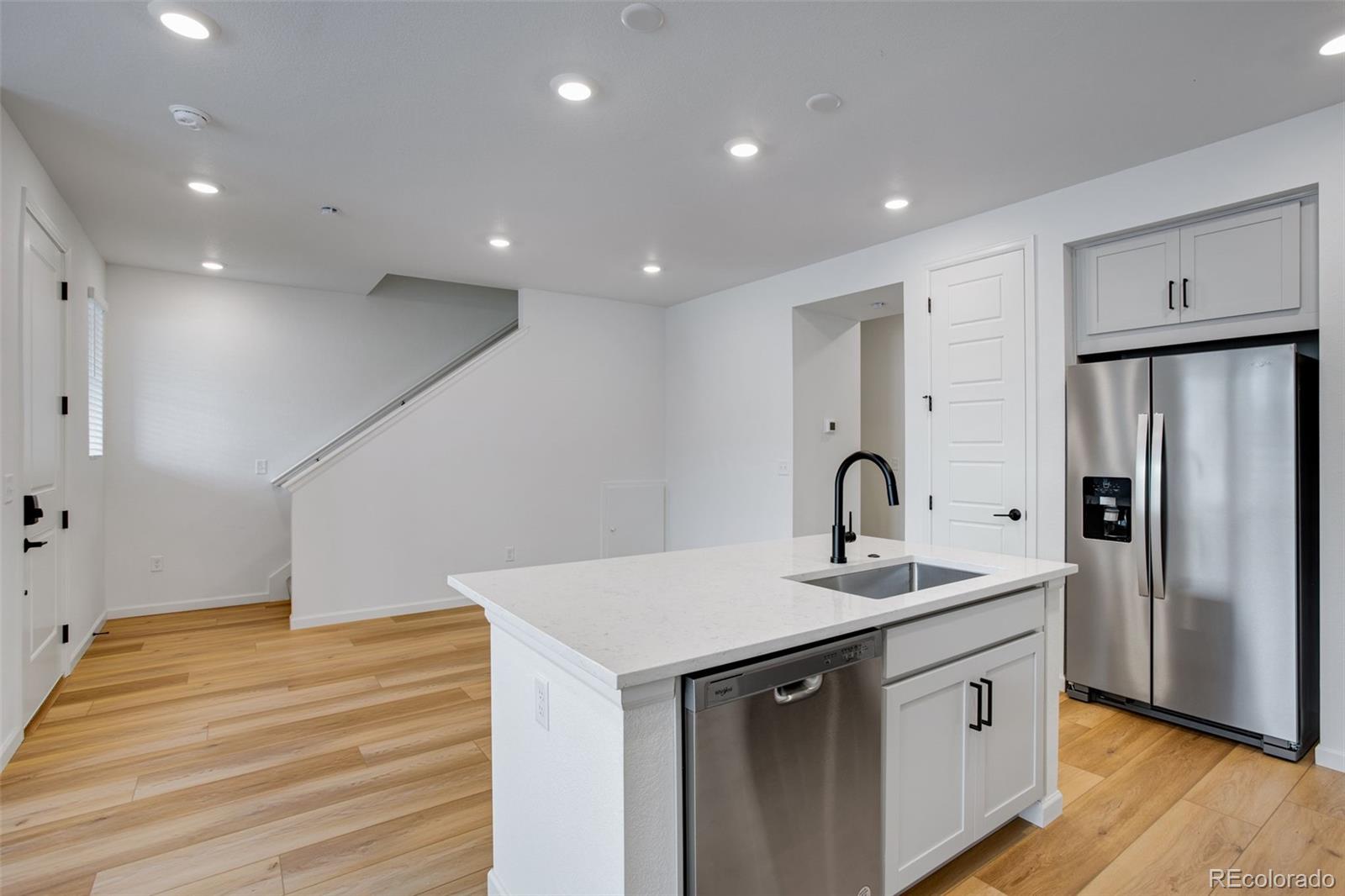 1765 Mount Meeker Avenue Berthoud, CO 80513 - Photo 19 of 37 a kitchen with stainless steel appliances granite countertop a sink and a refrigerator