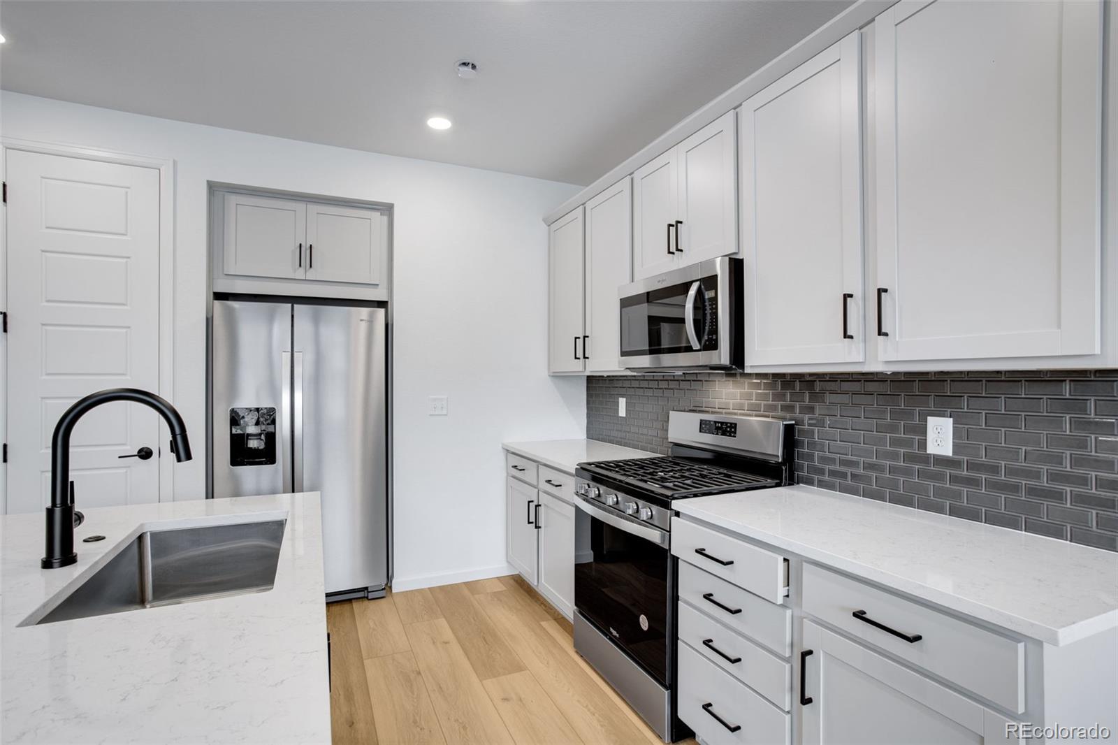 1765 Mount Meeker Avenue Berthoud, CO 80513 - Photo 20 of 37 a kitchen with granite countertop a stove and a sink