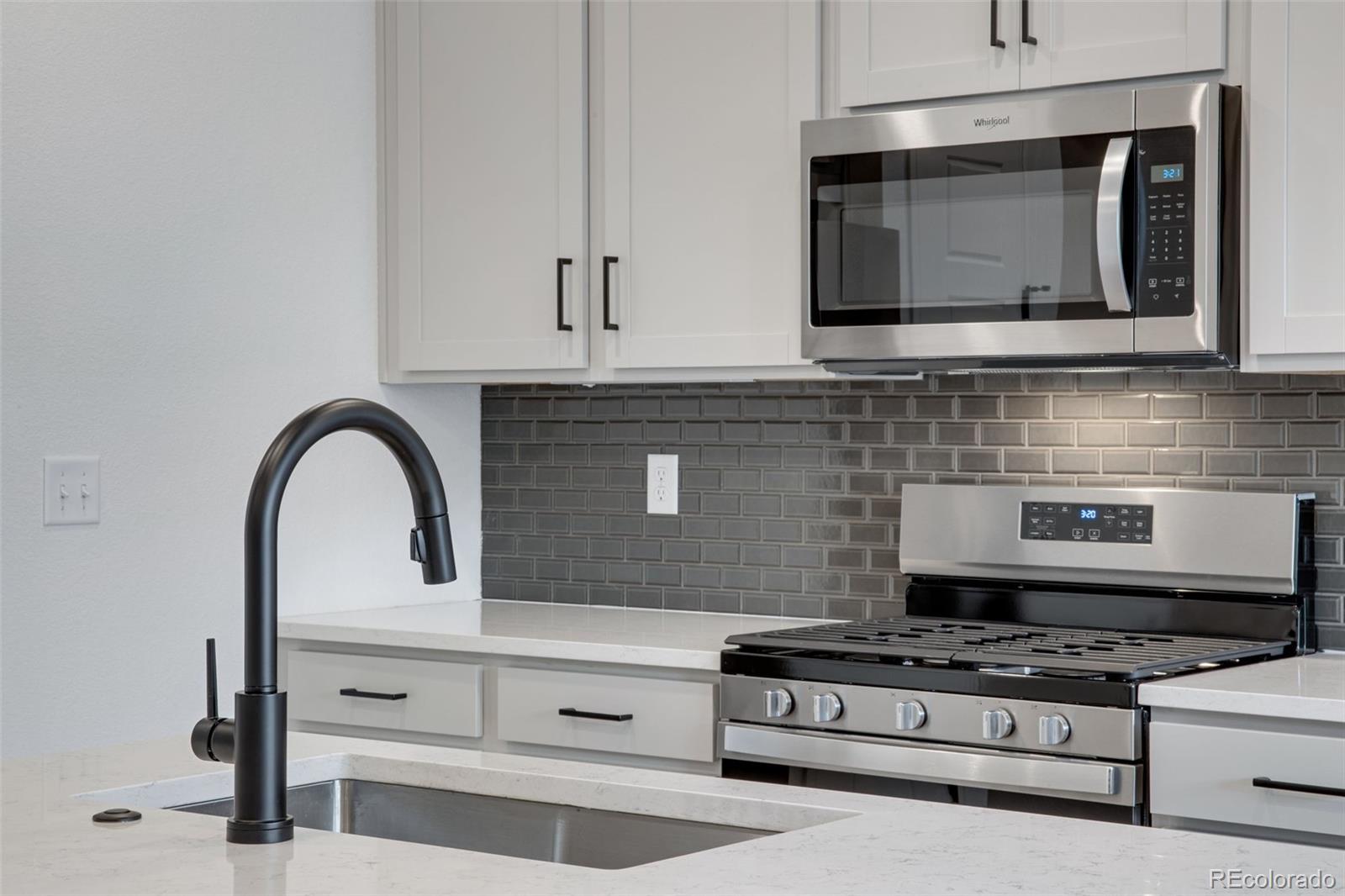 1765 Mount Meeker Avenue Berthoud, CO 80513 - Photo 21 of 37 a kitchen with granite countertop white cabinets stainless steel appliances and sink
