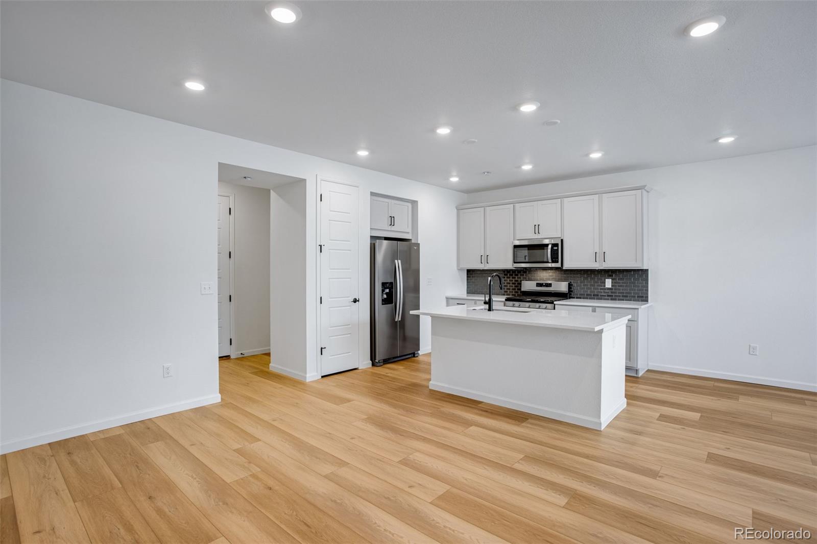 1765 Mount Meeker Avenue Berthoud, CO 80513 - Photo 7 of 37 a kitchen with stainless steel appliances granite countertop a refrigerator sink and white cabinets