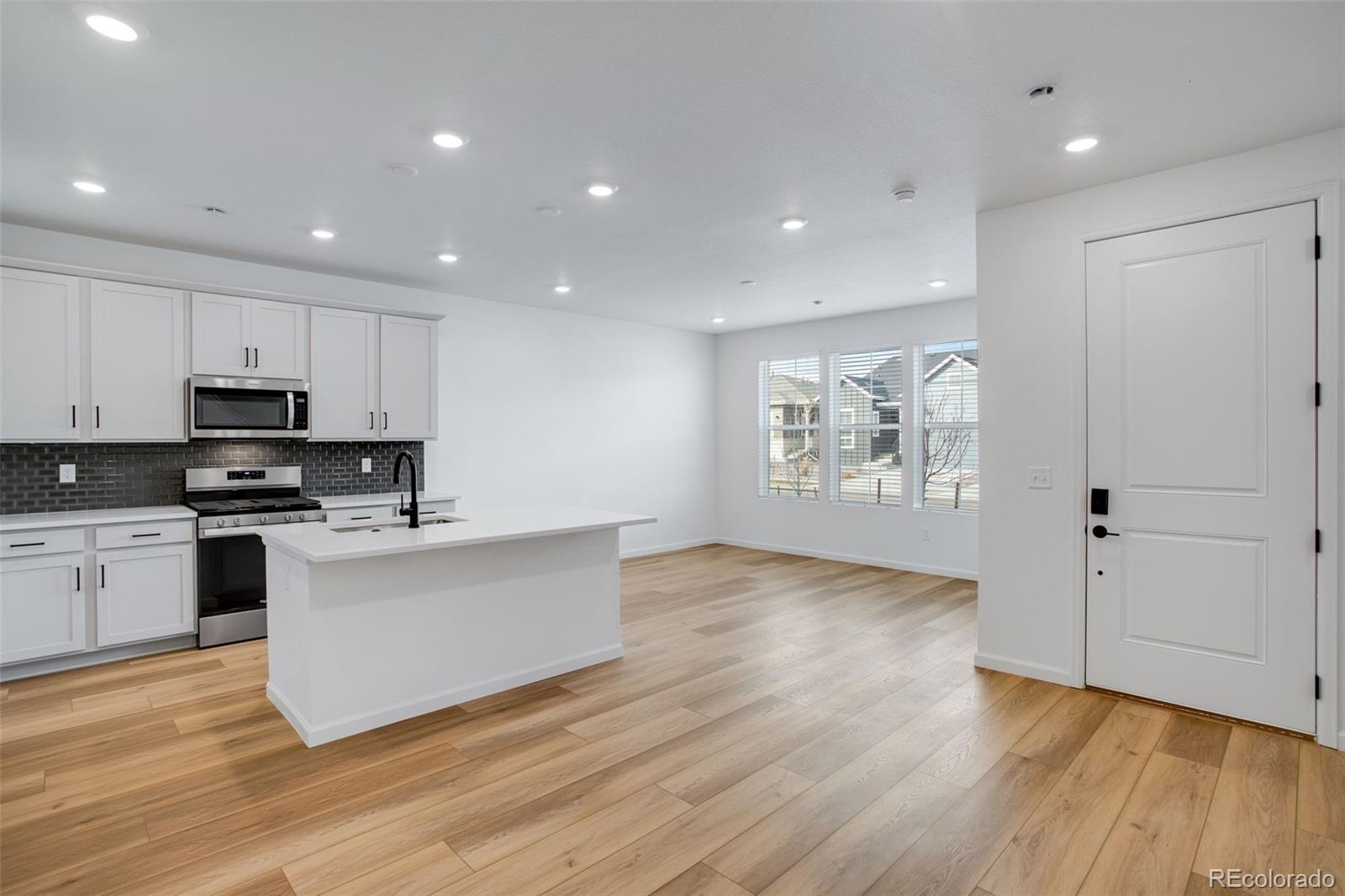 1765 Mount Meeker Avenue Berthoud, CO 80513 - Photo 8 of 37 a kitchen with wooden floors and white appliances