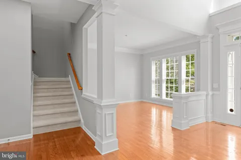 a view of front door with wooden floor and stairs