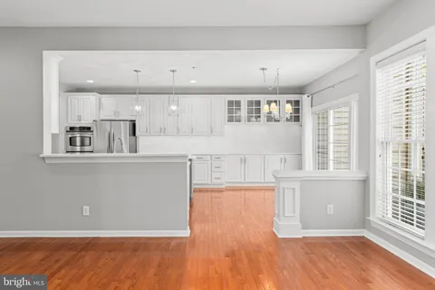 a large kitchen with kitchen island a large window cabinets a sink and stainless steel appliances