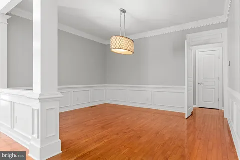 a view of an empty room with wooden floor and windows