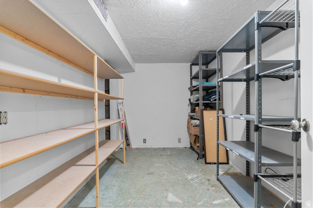 1489 North 400 West Bountiful, UT 84010 - Photo 32 of 47 Utility room featuring extensive built-in shelving, durable concrete flooring, and overhead lighting