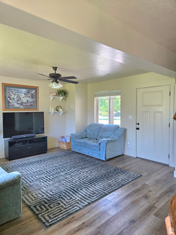 601 West 150 North, Unit 25 Springville, UT 84663 - Photo 4 of 29 Spacious living area featuring wood-finish flooring, a ceiling fan, and a paneled entry door