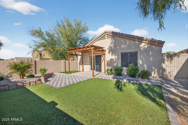 a view of a white house with a big yard and potted plants