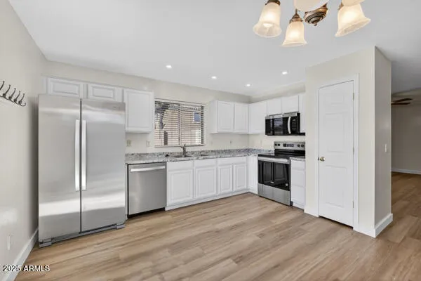 a kitchen with a refrigerator and white cabinets