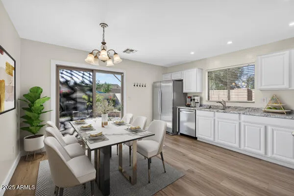 a kitchen with granite countertop white cabinets stainless steel appliances and living room view