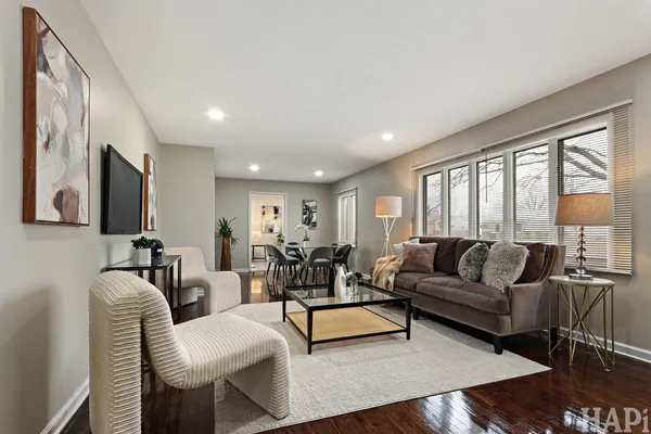 a living room with furniture wooden floor and a large window