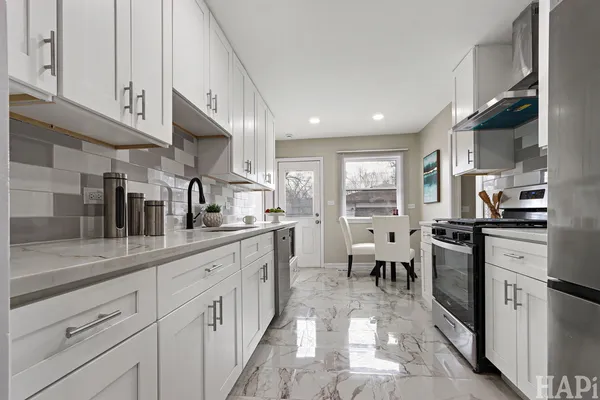 a kitchen with white cabinets and sink