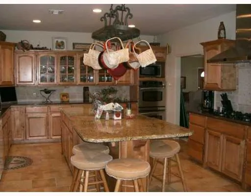a kitchen with a dining table cabinets and stove top oven
