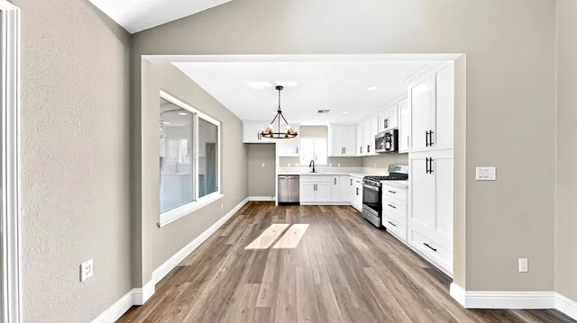 a kitchen with granite countertop a stove a sink and a refrigerator