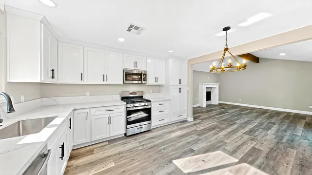 a kitchen with white cabinets and sink