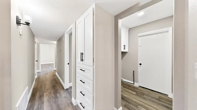 a view of empty room with wooden floor and ceiling fan