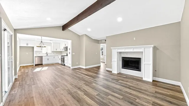 a view of a kitchen with kitchen island white cabinets and stainless steel appliances