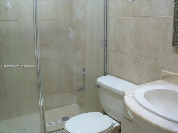 a white toilet next to a bathroom sink
